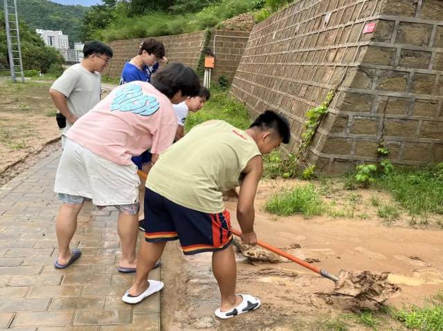 实践队与沈阳理工大学同学共同清理暴雨后土窑洞住处前堆积的淤泥