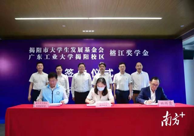 广东工业大学揭阳校区管委会常务副主任陈晖(中)、揭阳市大学生发展基金会名誉会长林辉勇(右)、揭阳市大学生发展基金会理事长宋旭彬(左)现场签订“榕江奖学金”协议。