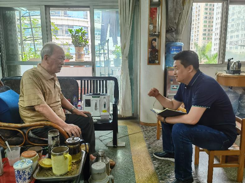 本刊记者孙进军(右一)正在东深供水工程建设者家中采访。(张嘉雯 摄)